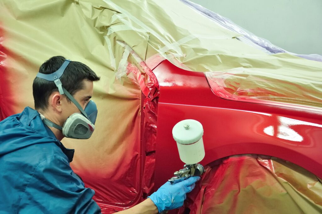 man-spray-painting-red-car