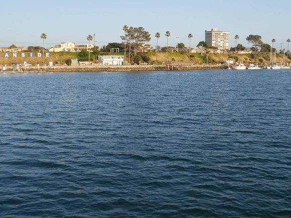 View of sea water from sailing boat or yacht, Oceanside harbor, summer vacations in California USA. Seascape from sailboat in port, tropical marina harbour. Pacific ocean coast, whale watching tour.